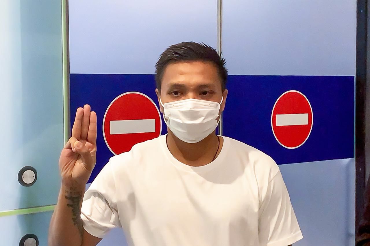 Pyae Lyan Aung raises the three-finger salute at Kansai International Airport in June 2021 after refusing to board his flight back to Myanmar.