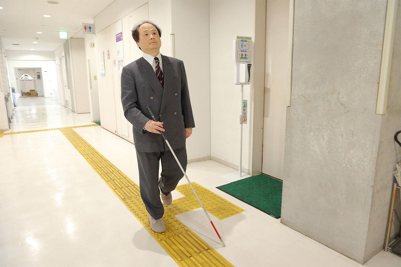 Professor Fukushima walking in the corridor of the University of Tokyo Research Center for Advanced Science and Technology. He uses the toilet unassisted. (© Hanai Tomoko)