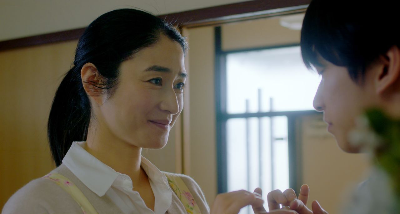 Reiko communicates with Satoshi after suddenly hitting upon the idea of finger braille. (© Throne/Karavan Pictures)