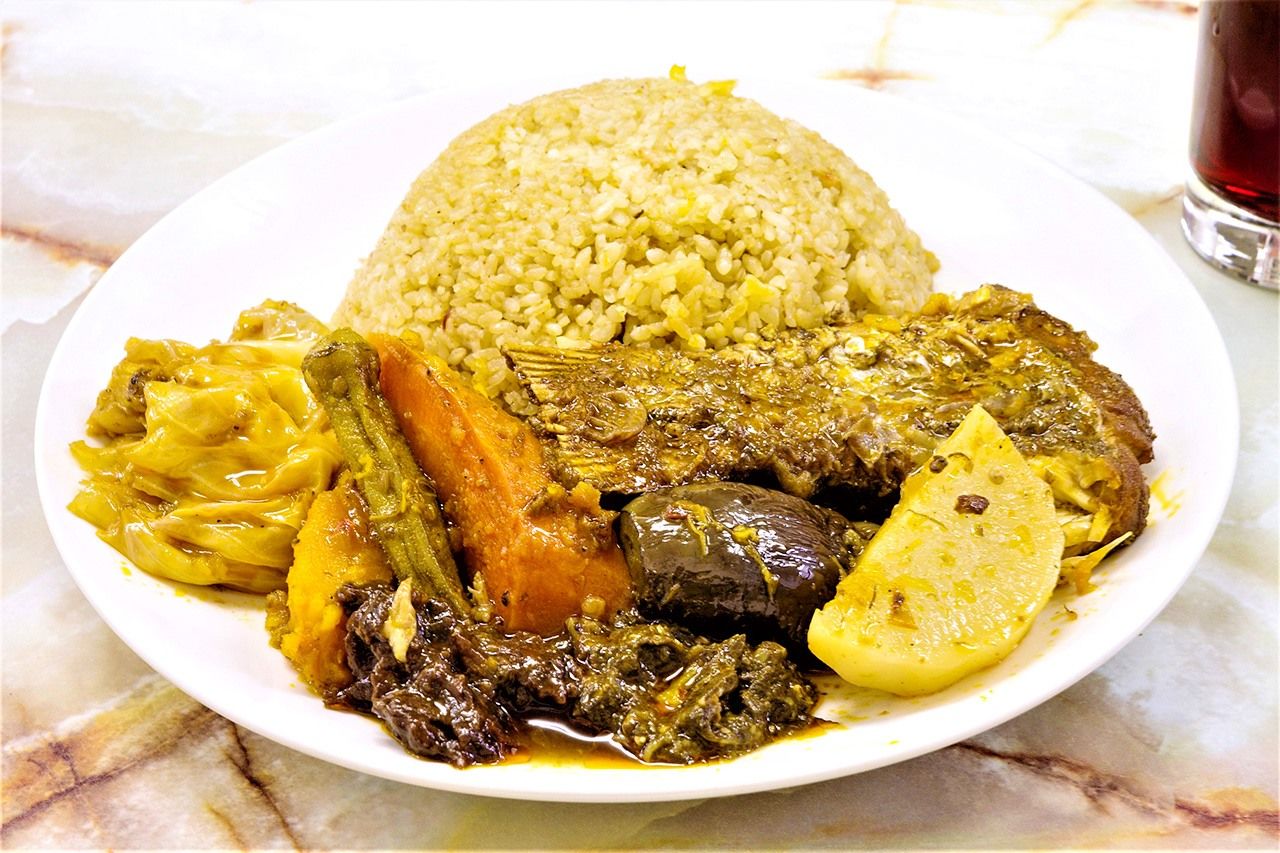 Thieboudienne is a savory dish of stewed rice, fish, and vegetables.