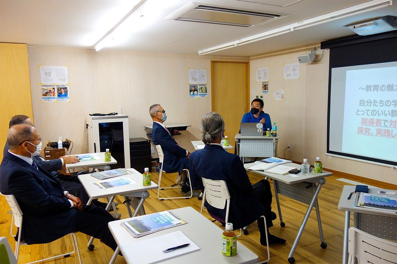 Ama now receives frequent visits from representatives of other local governments that are struggling with depopulation. Here, representatives from the village of Ogasawara, a remote island outpost in Tokyo, meet with Toyota Shōgo (in blue, at the desk at front) to learn about Ama’s strategies. (© Mochida Jōji)