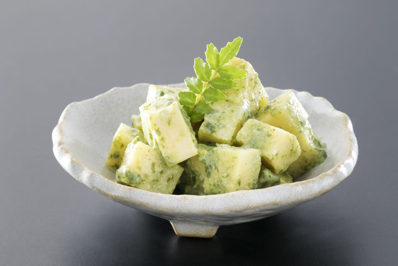 Young bamboo shoot dressed in white miso and ground sanshō, topped with young sanshō leaves. (© Pixta)