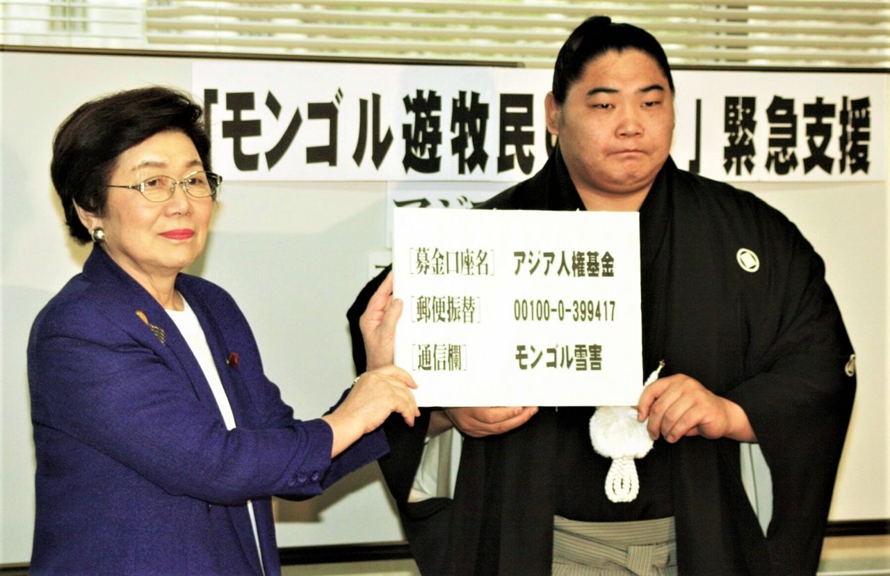 Kyokushūzan, right, and head of the Social Democratic Party Doi Takako call for donations to aid victims of record snowfalls in Mongolia in January 2001. (© Jiji)