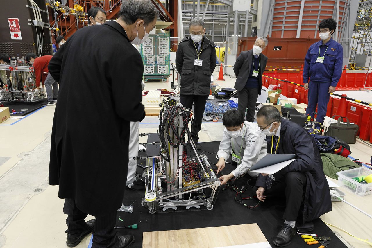 Even during breaks between test runs, the judges examine the robots. (© Yamada Shinji)