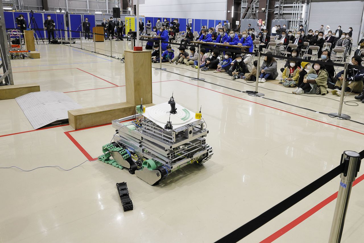 The robot entered by the team from the National Institute of Technology, Ichinoseki College (Iwate), suffered a broken caterpillar track shortly after the start of its run. The team won a special award for the ingenuity of its pen that is able to move in a spiral motion. (© Yamada Shinji)