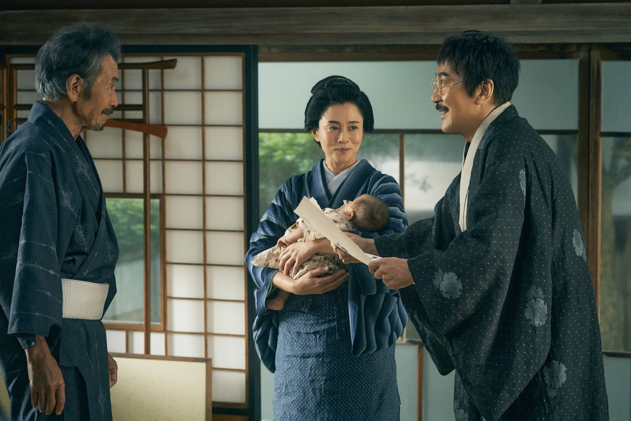 Masajirō (Played by Yakusho Kōji) returns from a business trip on learning of his first child’s birth. His own father, Kisuke (played by Tanaka Min), and wife Ichi (Sakai Maki) share in the joy. (© 2022 Ginga tetsudō no chichi Production Committee)