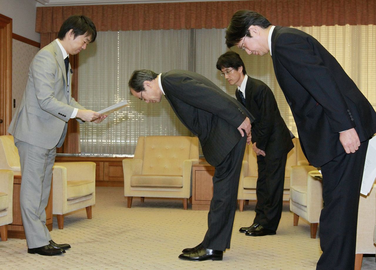 Officials from Asahi Shimbun Publications apologize to Osaka Mayor Hashimoto Tōru (left) on November 12, 2012, and present a report on the investigation into the article concerning him. (© Jiji)