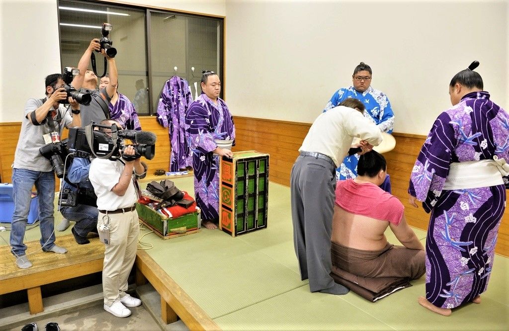 Yokozuna Hakuhō, after losing a match to Gōeidō on the twelfth day of the May 2015 tournament. Hakuhō sits with his back to reporters, unwilling to be interviewed. (© Kyōdō)