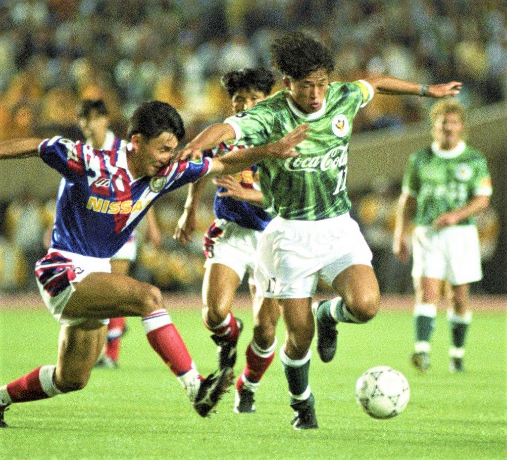 Miura Kazuyoshi, right, of Verdy Kawasaki dribbles the ball during the inaugural J. League match at the National Stadium in Tokyo on May 15, 1993. He would go on to be the J. League’s first MVP. Far from hanging up his cleats, the 56-year-old star plays to this day at Portuguese second division side Oliveirense. (© Kyōdō)