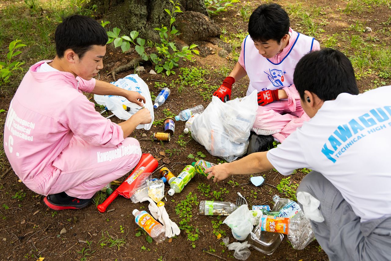Trash sorting. Smokers often discard cigarette butts in beverage cans or bottles. (© Nippon.com)
