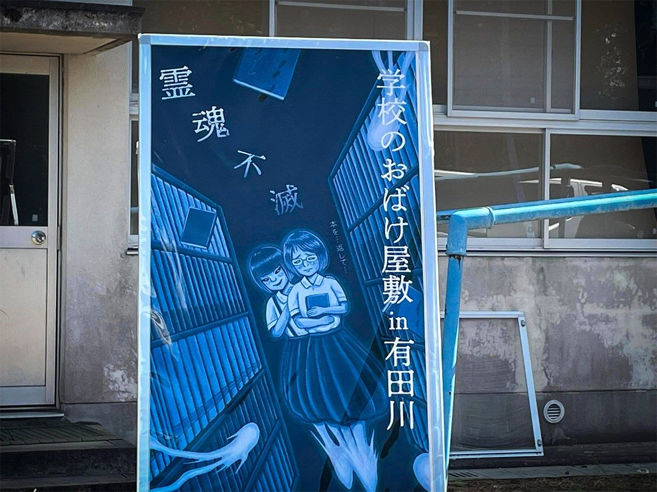In August 2023, a haunted house event was held at a closed-down elementary school in Aritagawa, Wakayama Prefecture. Participants took on the mission of getting a book from Hanako and carrying it back to the school library. (Courtesy Aritagawa municipal government; poster by children’s book author Yamamoto Takashi)