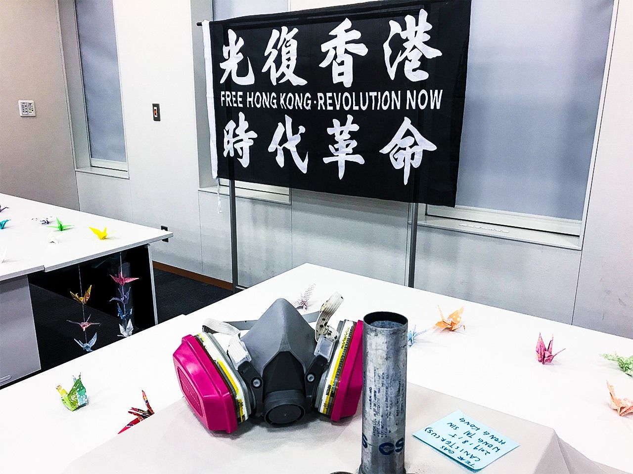 A scene from the “Global Solidarity” symposium held in Tokyo. Displays at the venue included gasmasks used by demonstrators, and empty tear-gas canisters.