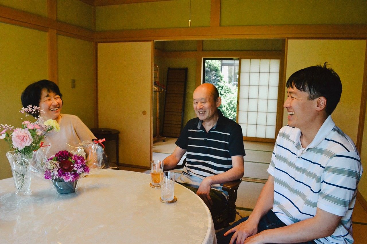 Yokota Hiroto, right, with his parents. (© Gotō Eri)