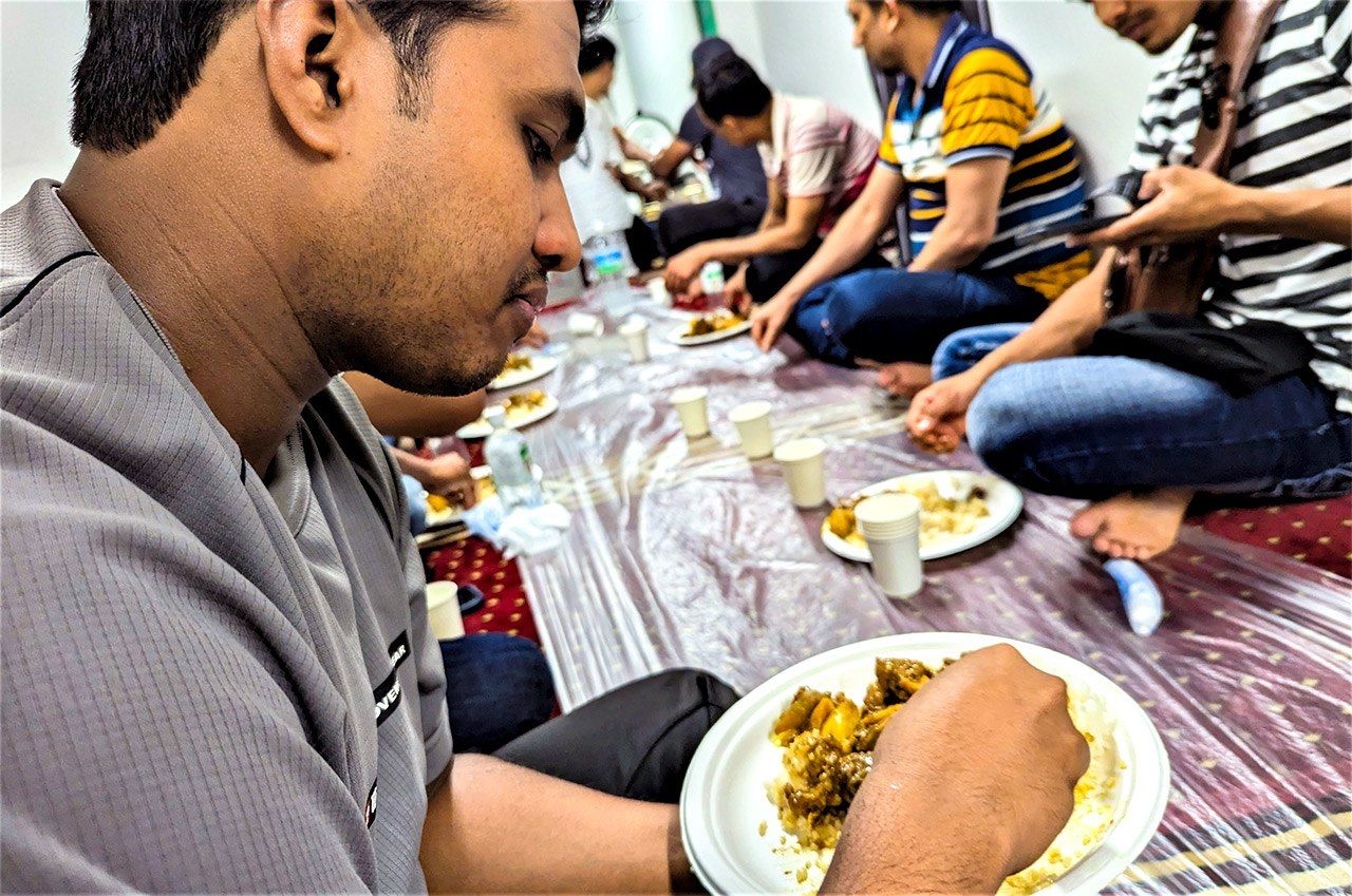 Eating curry at the mosque. The worshipers readily befriend the strange Japanese in their midst (© Kumazaki Takashi)
