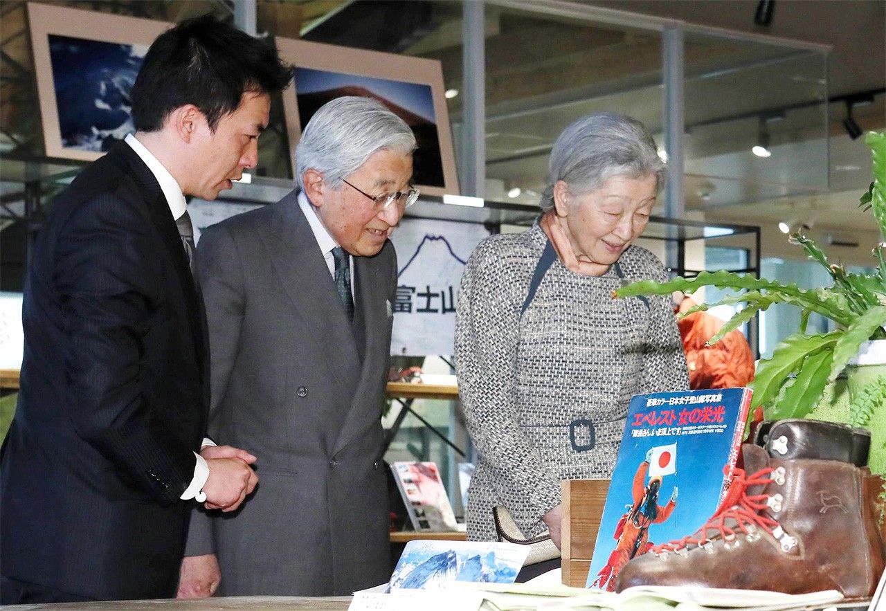 The imperial couple view the retrospective exhibition on Tabei Junko’s life, guided by her son Shin’ya, on March 29, 2017, in Akishima, Tokyo. (© Jiji)