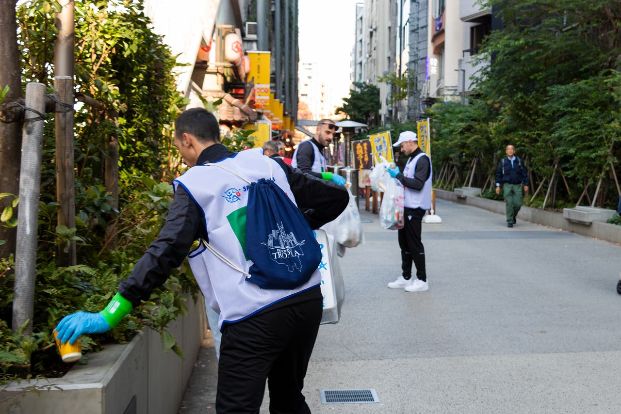 Each team developed unique strategies, like focusing on entertainment areas or side streets. This photo shows the Italian team searching for litter along dining-heavy district Shibuya Yokochō.