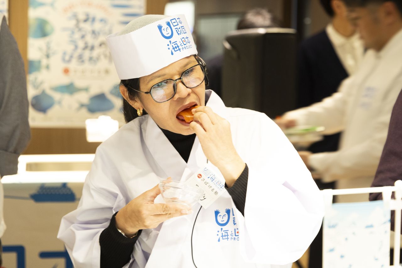 An attendee gives salmon-flavored sashimi konnyaku a try.