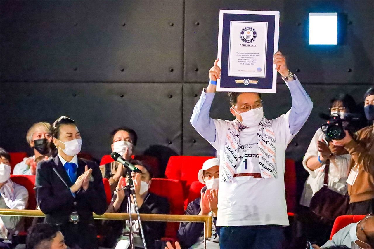 Tanaka holds up the official certificate of the group’s Guinness World Record. (Courtesy of Tanaka Hirokazu)