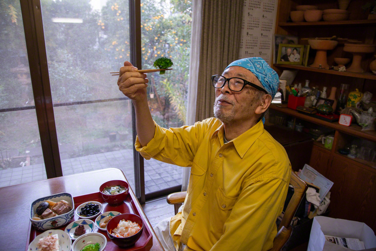 Nagayama takes a moment to admire a piece of broccoli, noting its resemblance to a large tree. Mindful eating makes for more delicious and healthful meals. (© Ōnishi Naruaki)
