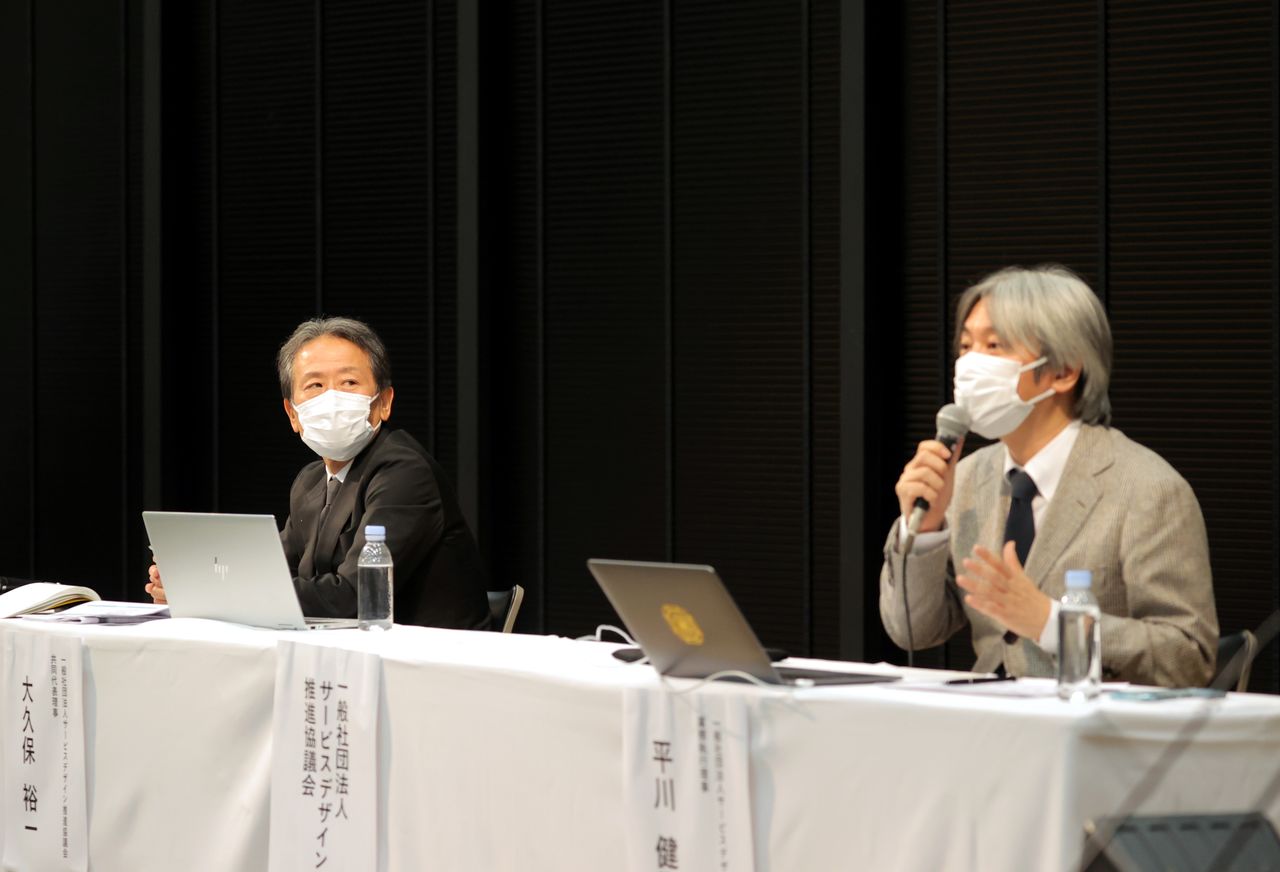  Ōkubo Yūji (left), representative director of the Service Design Engineering Council, a Dentsū affiliate, and the Council’s executive director, Hirakawa Kenji, address the media on June 8, 2020, about their administration of government grants. (© Jiji)