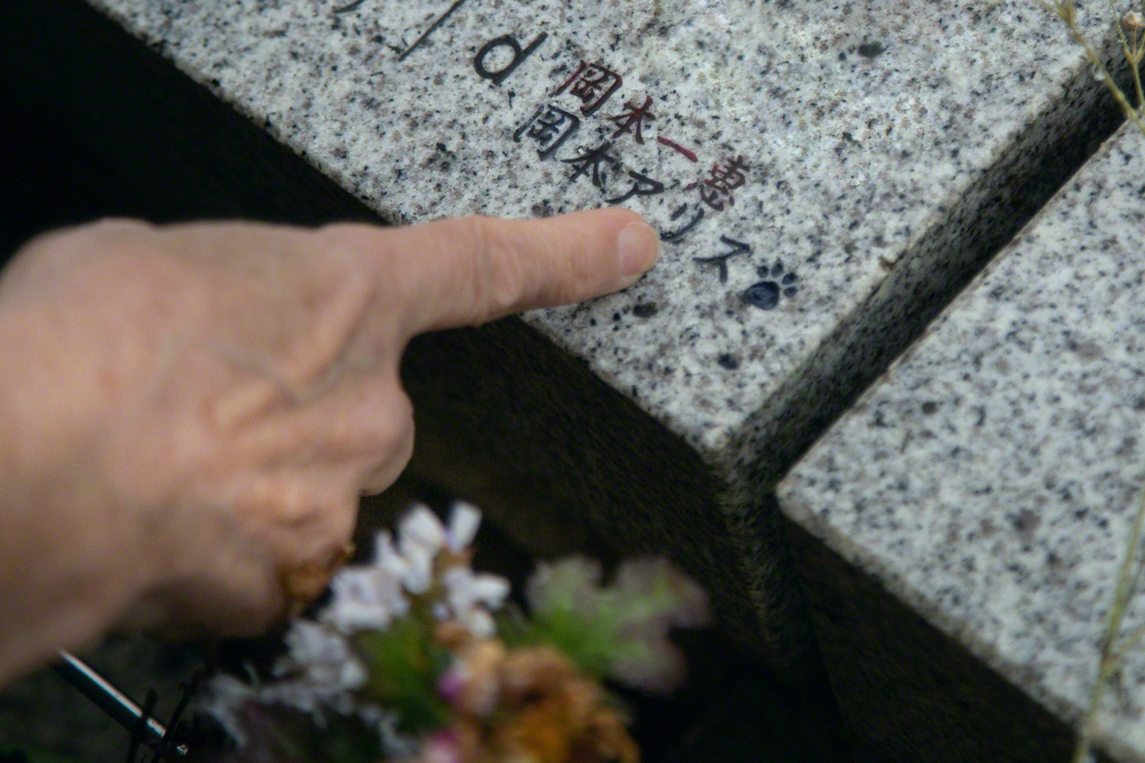 Okamoto points to her cat’s name Alice, which is next to her name. (© Ōnishi Naruaki)