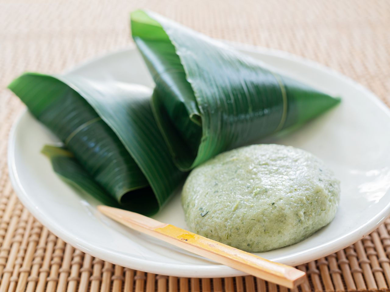 Steamed dumplings made with nama-fu, fragrant yomogi (mugwort), and stuffed with adzuki paste or other sweet fillings. (© Pixta)