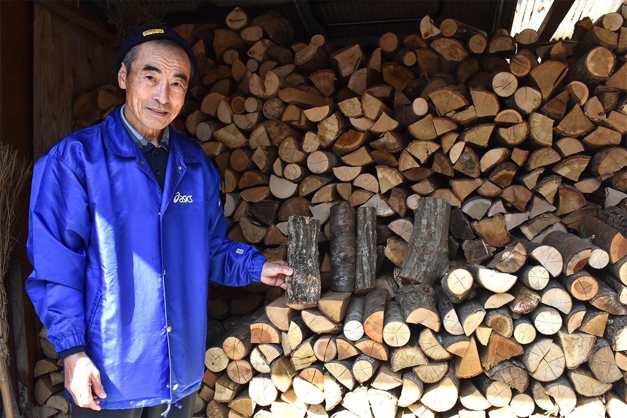 Maekawa Hisashi with firewood gathered in the forest. (© Abe Haruki)