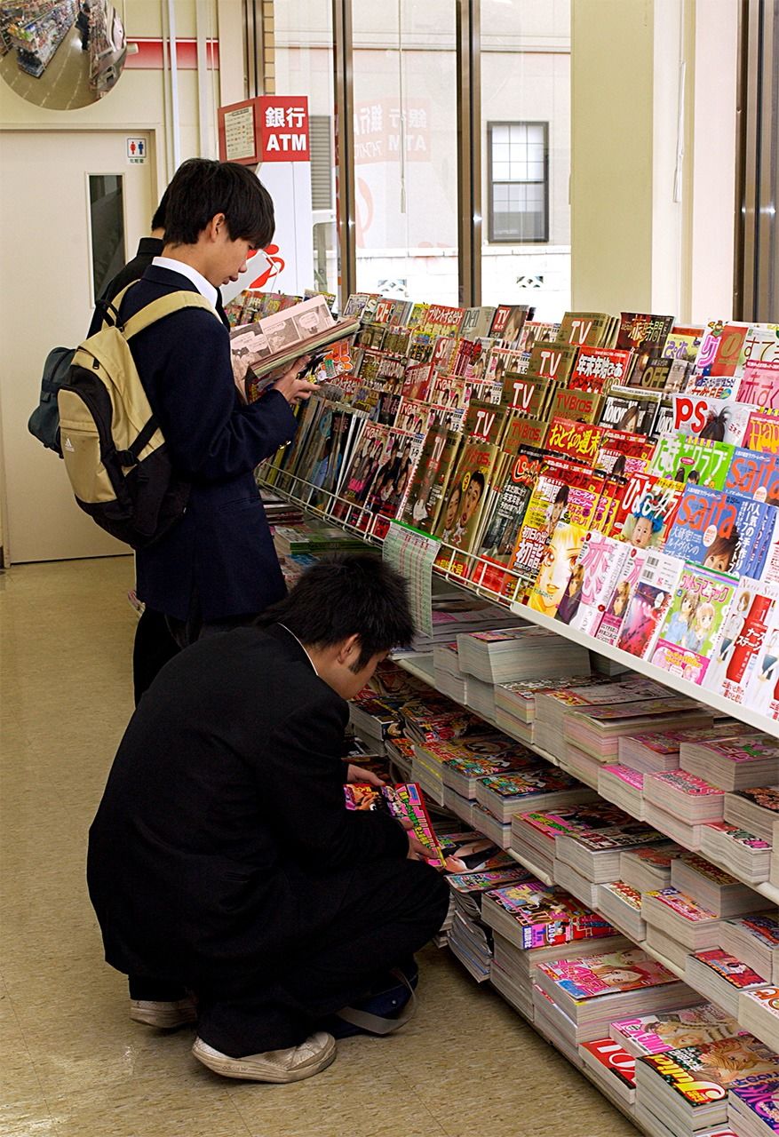 Students read manga magazines in a convenience store in the early 2000s. (© Jiji)