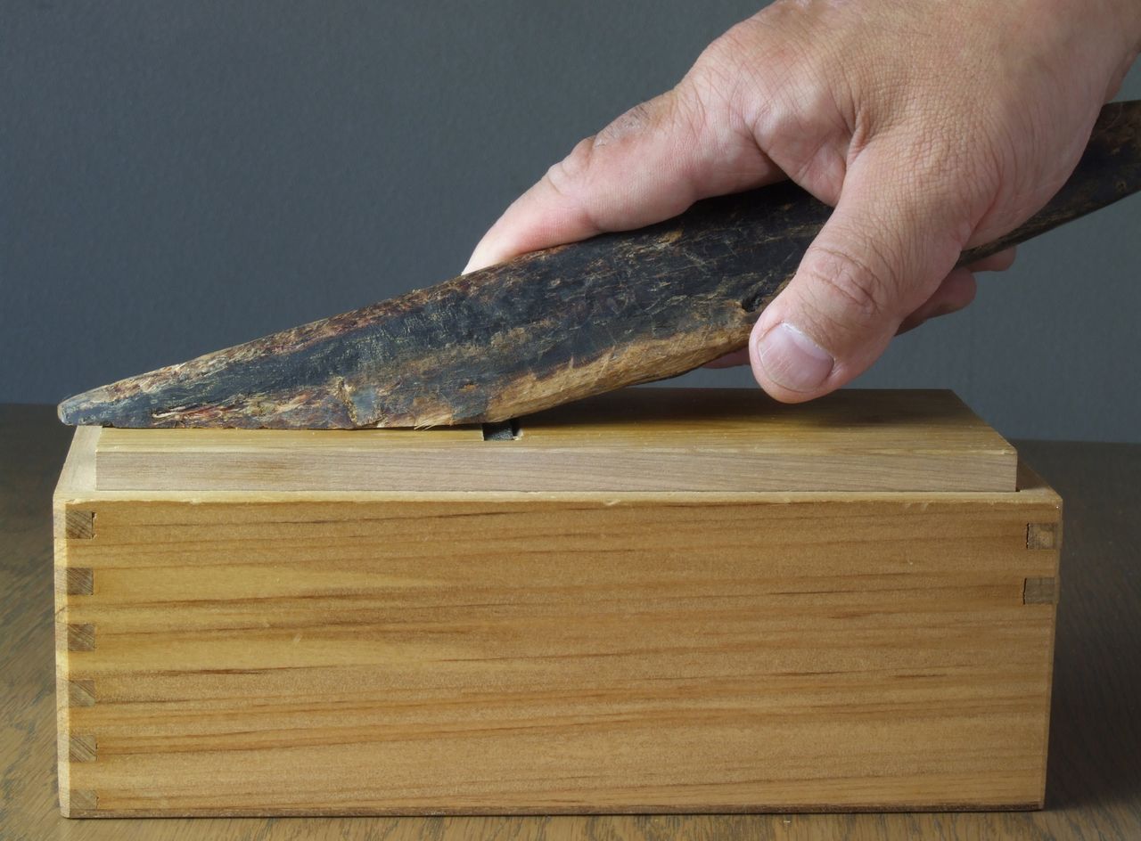 The blade at the top shaves the cured bonito into flakes, which are caught in the box below. (© Pixta)