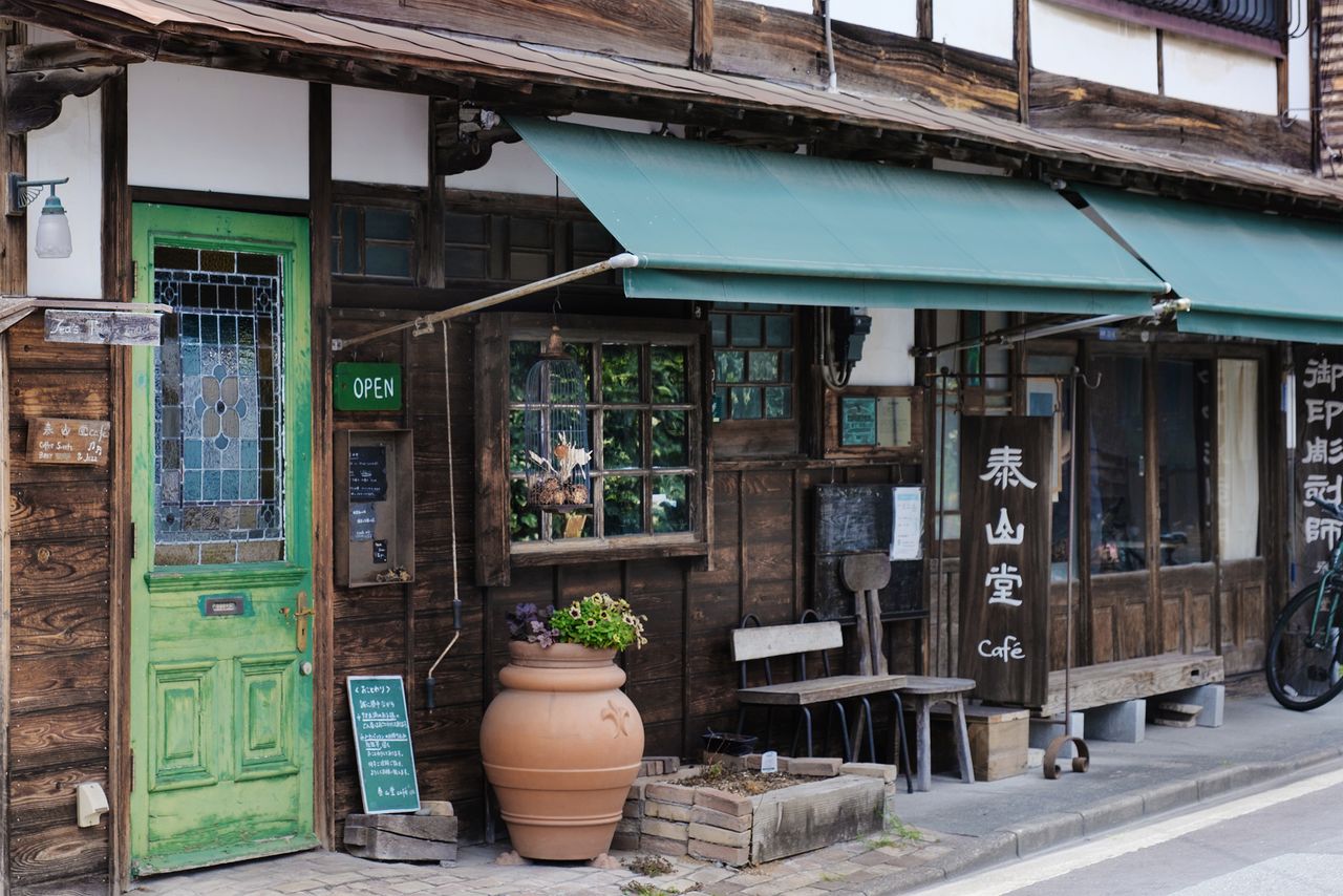 The café’s eye-catching antique green door. (© Kawaguchi Yōko)