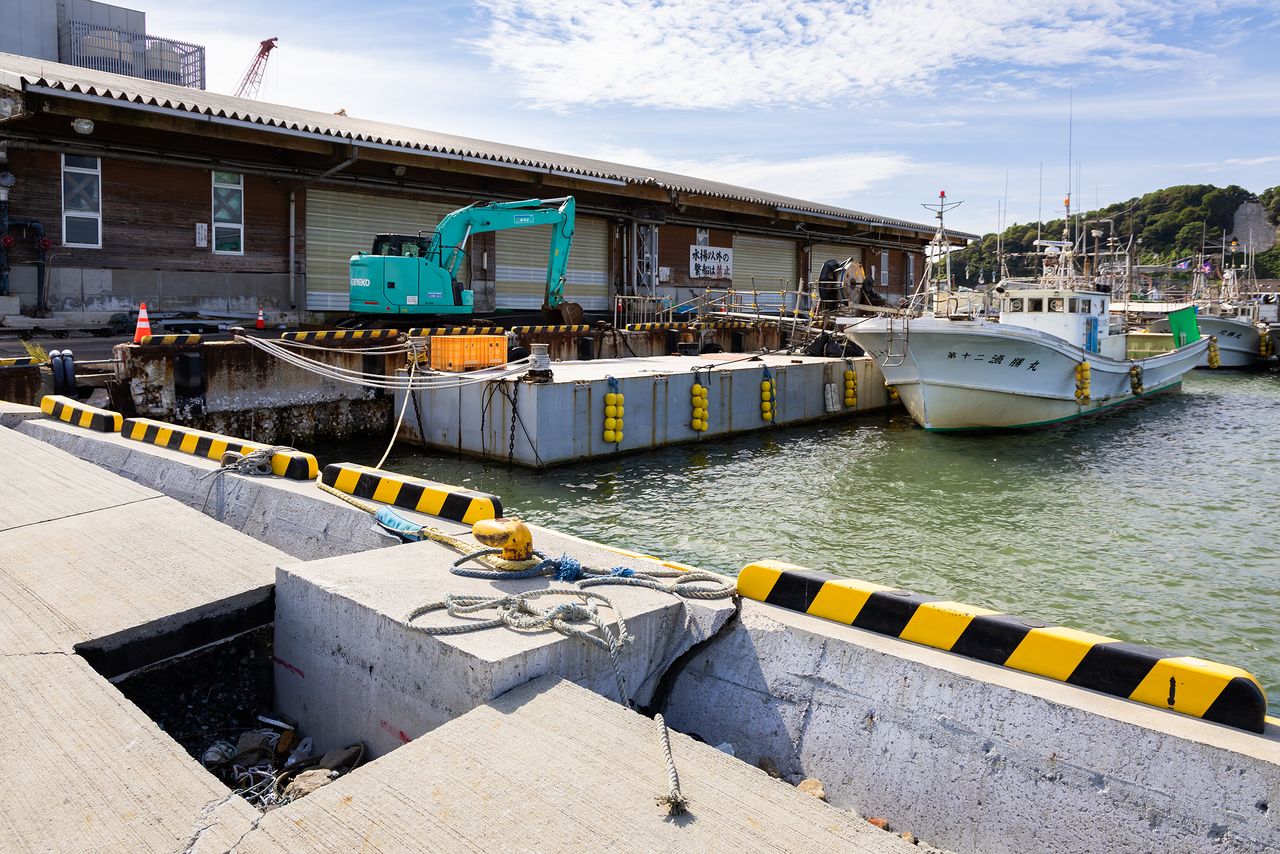 A boat docked next to a temporary pier. The seafloor at the original unloading site has risen by about 1.5 meters. (© Nippon.com)