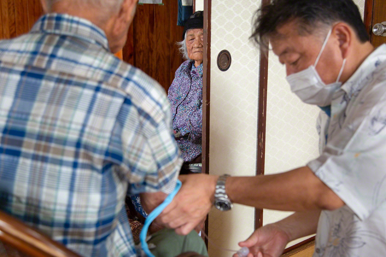 The woman watches on, concerned for her husband’s health. (© Ōnishi Naruaki)