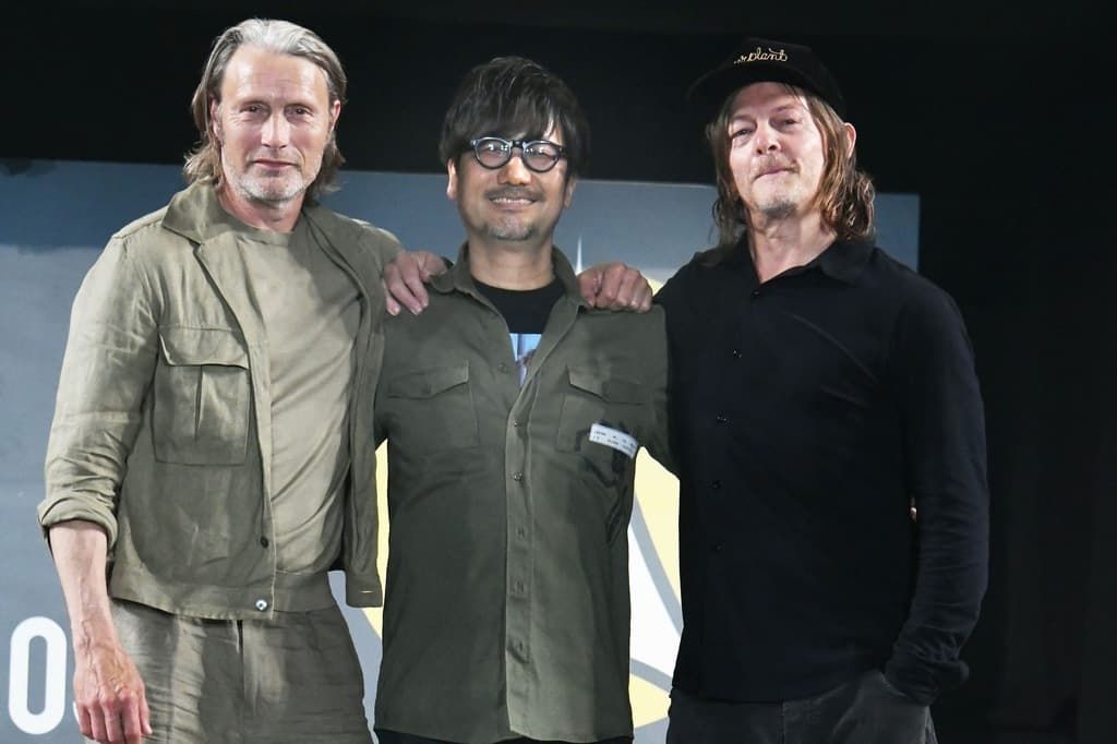 Kojima Hideo (center), stands between Death Stranding stars Mads Mikkelsen (left) and Norman Reedus at an Osaka Comic Con event on May 5, 2024. (© Jun Sato/WireImage/Getty/Kyōdō)