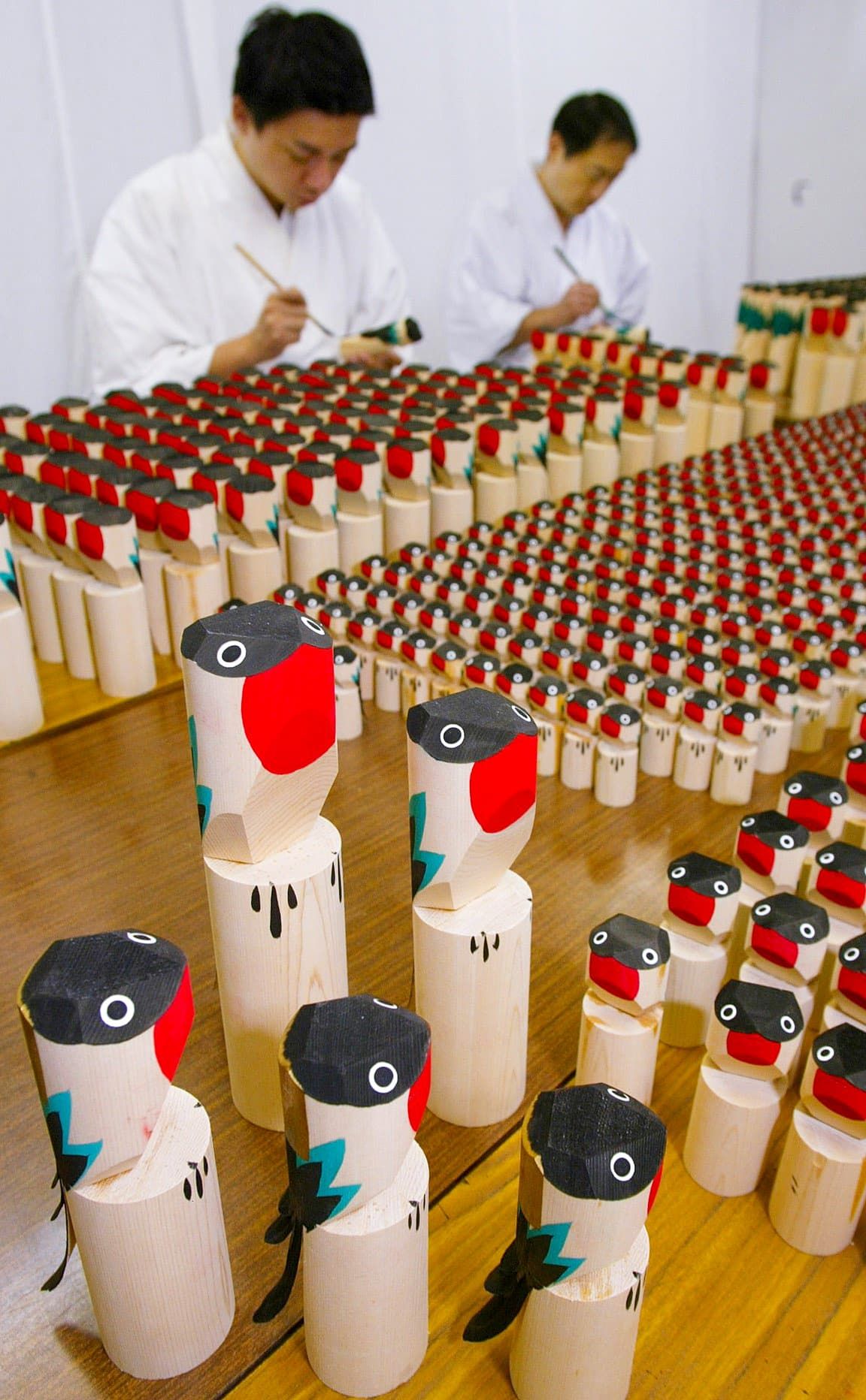 Preparing wooden bullfinch figures at Kameido Tenjin Shrine. These are almost the same as those sold in the Edo period. (© Jiji)