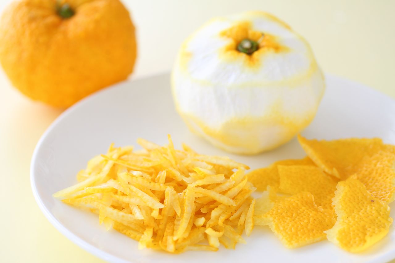 A freshly zested yuzu. (© Pixta)