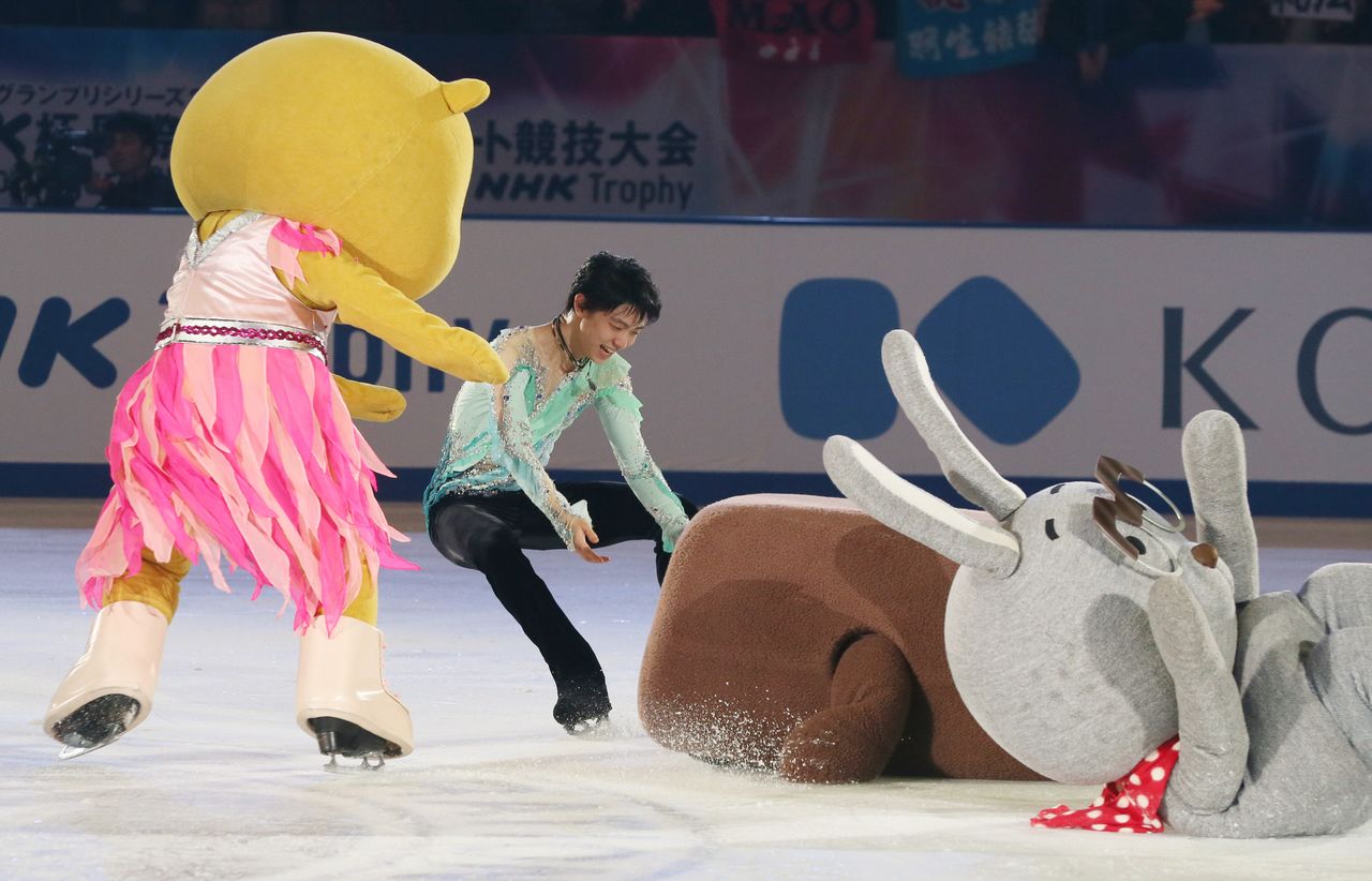 Hanyū Yuzuru extends a hand to help NHK mascot Dōmo-kun, who has fallen during exhibition skating on November 29, 2015. (© Jiji)