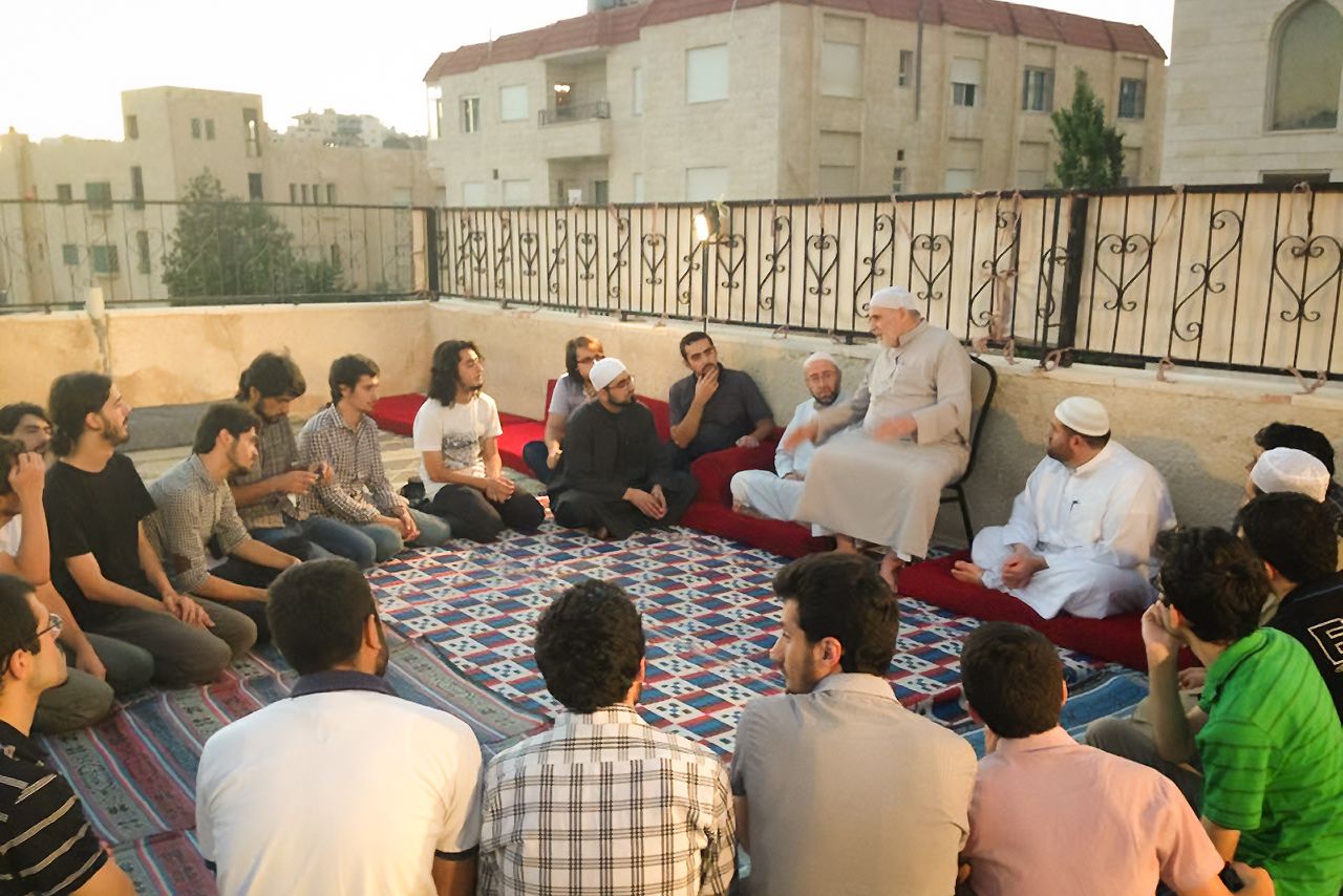A 2013 study session in Jordan, with students sitting in a circle around a renowned Islamic scholar, as is done traditionally. (© Yamamoto Naoki)