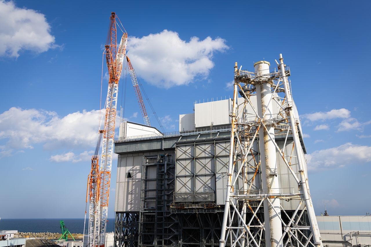 The Unit 1 reactor building, now enveloped in a giant cover, in January 2026. (© Hashino Yukinori)
