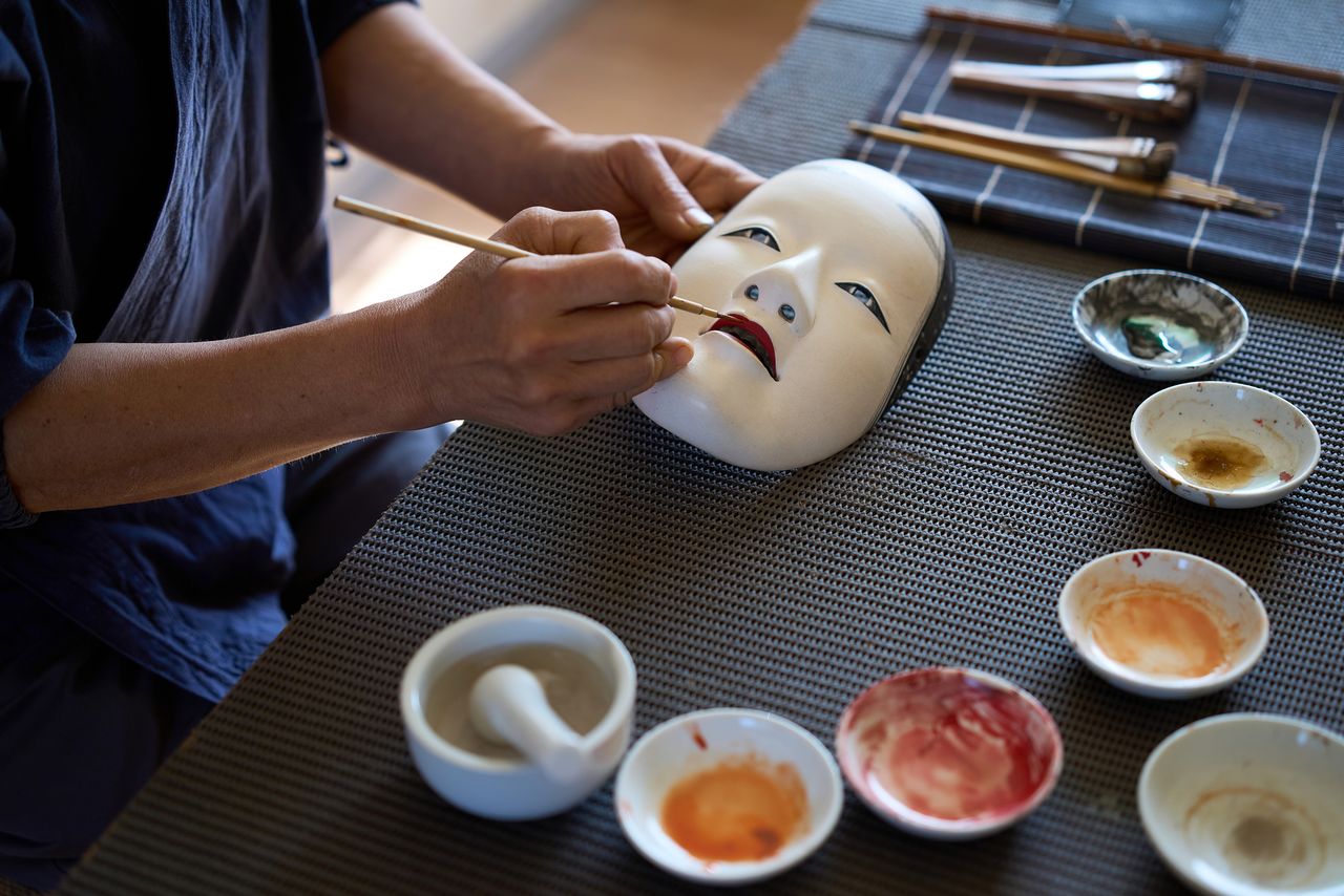 Painting the mouth of a waka-onna (young woman) mask—an especially delicate task. (© Kuratani Kiyofumi)