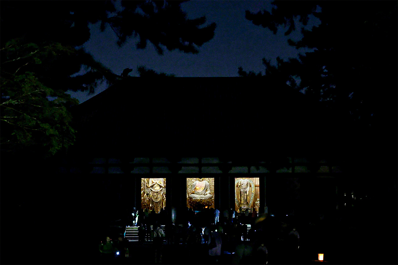 Every year at the time of the harvest moon, a ceremony known as the Kangetsu sanbutsu-e is held in the Kondō main hall. In the darkness of night, the three great images can be seen shining through the opened doors of the hall, illuminated by light from within. From left: Thousand-Armed Kannon, Rushana Buddha, Yakushi Nyorai. (© Muda Tomohiro)