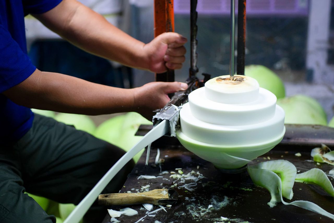 The long, thin strips are created by mounting the gourd on a motor-driven rod and shaving it with a special planer-style blade as it rotates. (© Pixta)