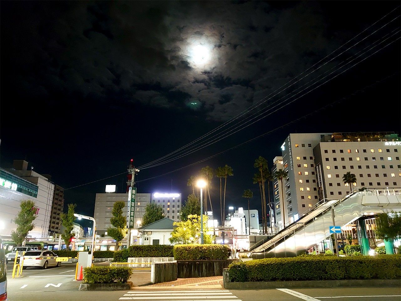 The quiet street in front of Tokushima station under the cloud-covered full moon.