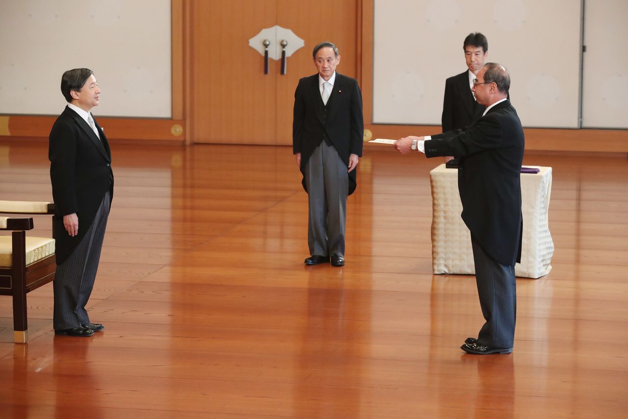 Emperor Naruhito, at left, invests Nishimura Yasuhiko as grand steward of the Imperial Household Agency at the Matsu-no-ma Hall of Tokyo’s Imperial Palace on December 17, 2019, as Suga Yoshihide (then chief cabinet secretary) looks on. (© Jiji; pool photo)