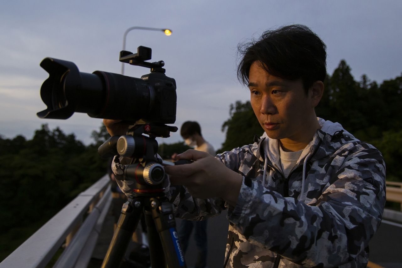Hashimuki setting up his camera at dawn. (© Nippon.com)