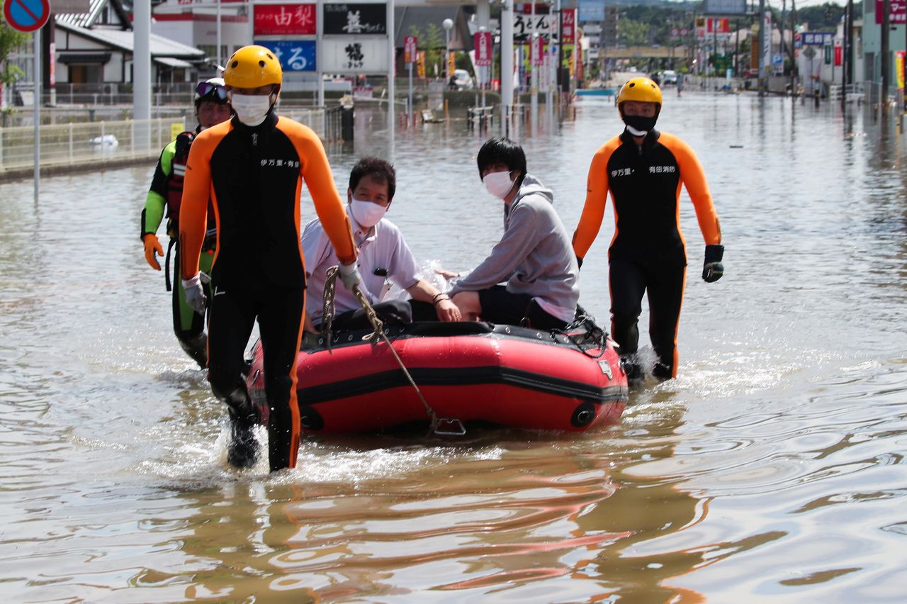Rescue workers transport people using a boat along a flooded street in Takeo, Saga Prefecture, western Japan, August 15, 2021. REUTERS/Kim Kyung-Hoon