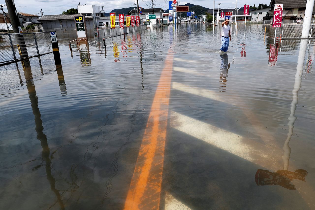 A pedestrian looks out along a flooded street in Takeo, Saga Prefecture, western Japan, August 15, 2021. REUTERS/Kim Kyung-Hoon
