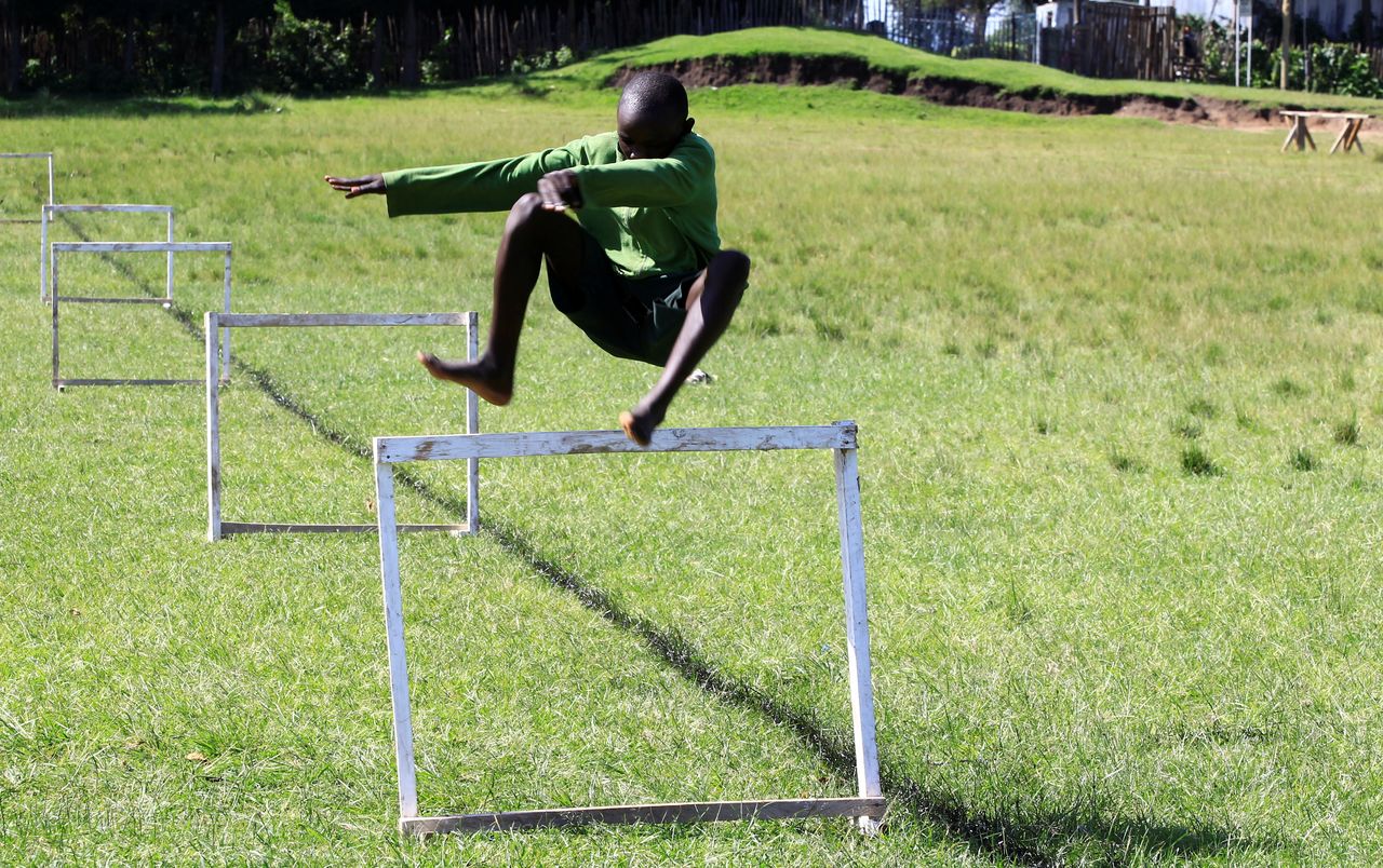 A pupil at Kamoi Primary school jumps a hurdle as he runs during steeplechase exercise session at their schools