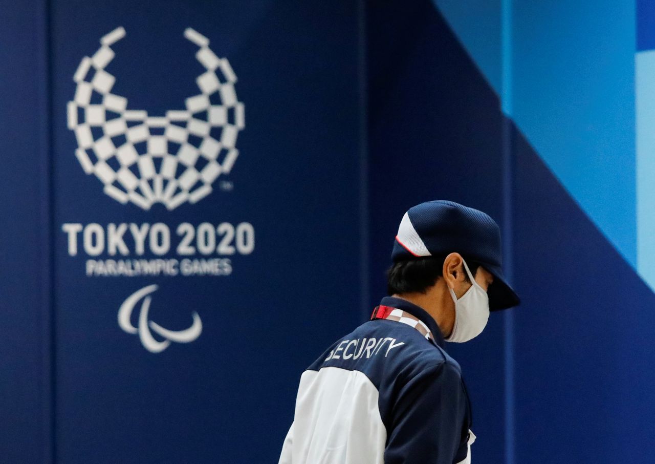 A security officer wearing a protective face mask walks past the logo of Tokyo 2020 Paralympic Games, amid the coronavirus disease (COVID-19) pandemic, in Tokyo, Japan, August 16, 2021. REUTERS/Issei Kato