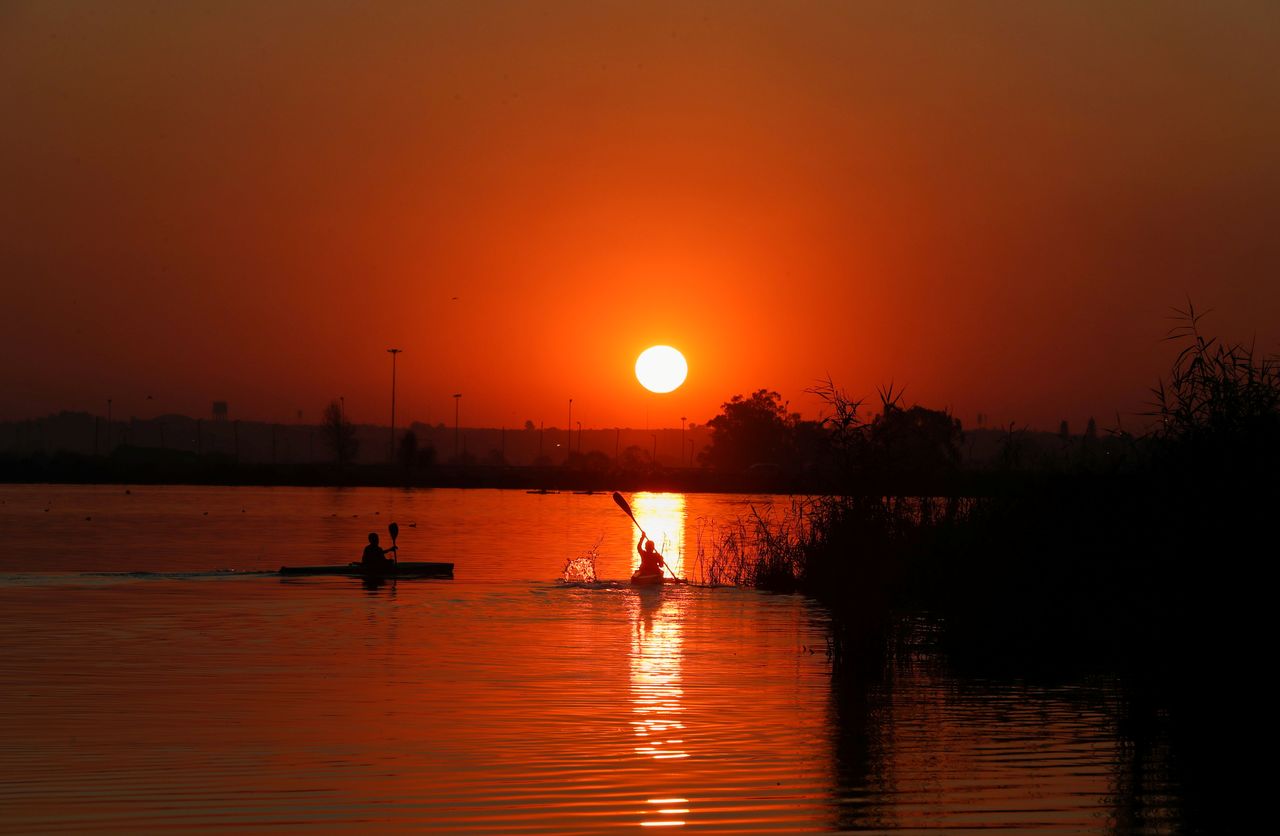 Canoeists are seen during training as the sun sets at the Orlando Dam in Soweto, South Africa, June 21, 2021. REUTERS/Siphiwe Sibeko