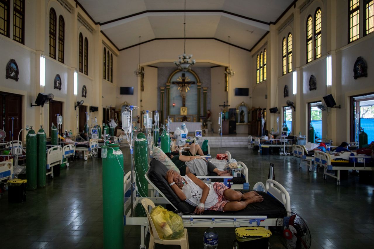 Coronavirus disease (COVID-19) patients lie in beds after being admitted in the chapel of Quezon City General Hospital, turned into a COVID-19 ward amid rising infections, in Quezon City, Metro Manila, Philippines, August 20, 2021. REUTERS/Eloisa Lopez